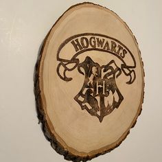 the hogwarts crest is carved into a piece of wood