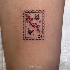 a small tattoo on the back of a woman's leg with flowers and butterflies