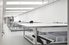 an empty office with white walls and tables in the foreground, open shelves on either side