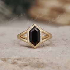 a gold ring with a black stone in the center