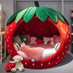 a bed made to look like a strawberry with stuffed animals on the bottom and inside