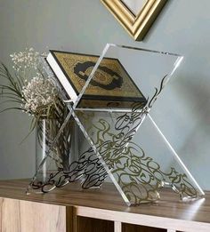 a vase filled with flowers sitting on top of a wooden table next to a mirror