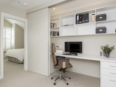 a bedroom with a bed, desk and shelves