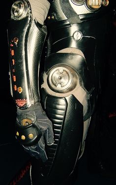 a close up of a pair of black and silver motorcycle boots with gold buttons on the soles