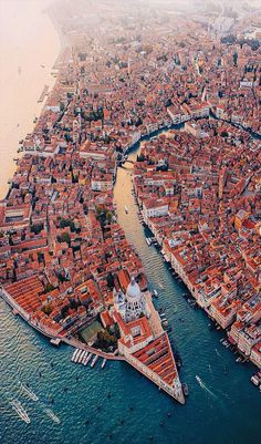 an aerial view of a large city with lots of buildings and boats in the water