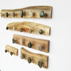 three wooden pegs with rocks on them mounted to the wall