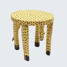 a yellow and black polka dot stool with legs