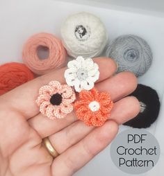 crochet flowers are in the palm of someone's hand