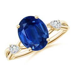 an oval blue sapphire and diamond ring with two diamonds on the band, set in yellow gold