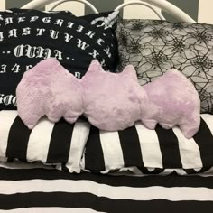 two pink teddy bears are laying on the pillows in this black and white bedding