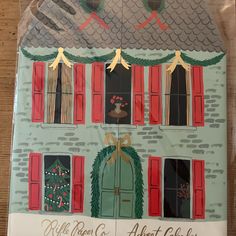 a christmas card with an image of a house on the front and red shutters