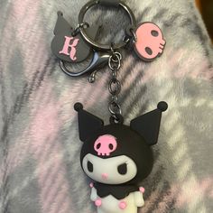 a black and white keychain with a pink skull on it's face