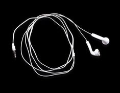 an earphone is laying on top of the headphones in front of a black background