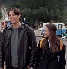 a young man and woman walking down the street