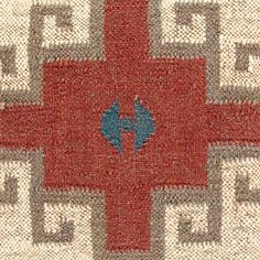 a red, white and blue rug with a cross on the center is seen in close up