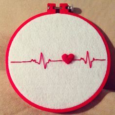 a red and white embroidery with a heart on it