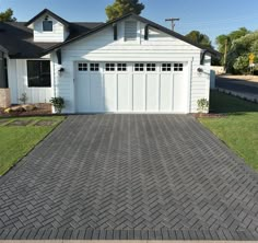 a white house with a brick driveway in front