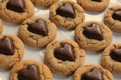 there are many cookies with chocolate in the middle on this plate and one cookie has a heart