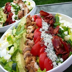 a salad with bacon, tomatoes and lettuce on it is ready to be eaten