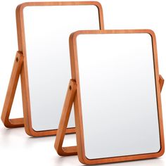 two wooden mirrors sitting next to each other