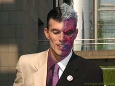 a man in a suit and tie with his face painted purple