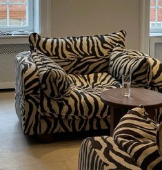 a zebra print couch and chair in a living room with two chairs next to each other