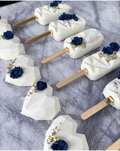 several popsicles with blue flowers on them sitting on a marble counter top next to each other