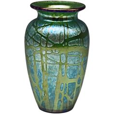 a green and blue vase sitting on top of a table