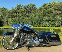 a black motorcycle parked next to a lake