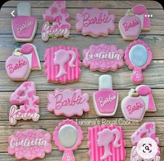 pink and white decorated cookies with baby's name in the middle on a wooden table