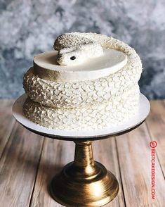 a cake with white frosting and a sheep on top is sitting on a stand