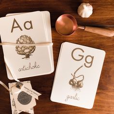 two coasters sitting on top of a wooden table next to a cup and spoon