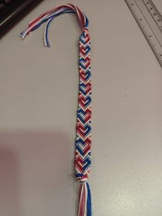 a red, white and blue braided tie on a table