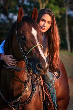 a woman is standing next to a brown horse with white stripes on it's face