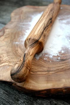 a piece of wood that is on top of a wooden board with a knife in it