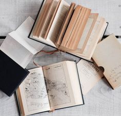 an open book sitting on top of a table next to some papers and pencils