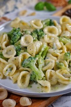 a white plate topped with pasta and broccoli