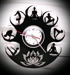 a clock with silhouettes of people doing yoga in the middle of it's face