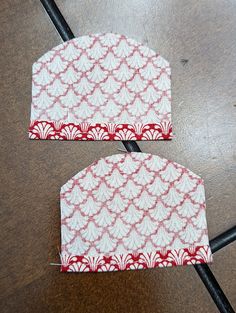 two red and white tags sitting on top of a table