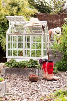 a woman is working in the garden with her red boots and gardening equipment on the ground