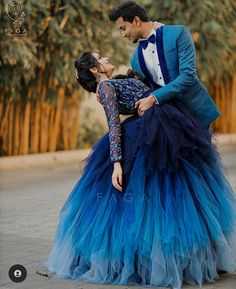 a man in a tuxedo and a woman in a blue dress dance together