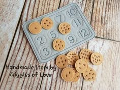 some cookies are laying on the floor next to a cookie sheet with holes in it