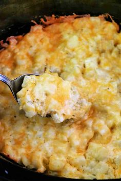 a spoonful of macaroni and cheese being scooped from the casserole