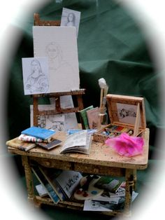 a wooden table topped with lots of art supplies