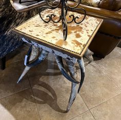 a table that has some kind of animal skin on it and is sitting in front of a couch