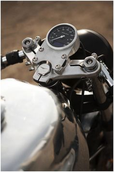 a close up of the speedometer on a motor bike's handlebars