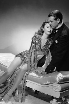 an old photo of a man and woman posing on a bed in a room with fur rugs