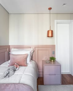 a small child laying on top of a bed next to a night stand and nightstand