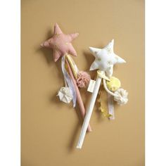 three star shaped hair clips on top of each other next to an orange and yellow wall