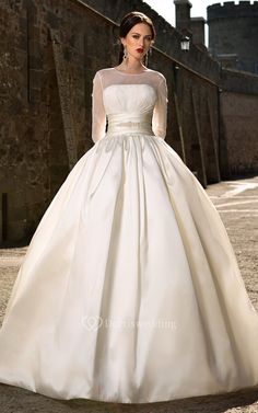 a woman in a white wedding dress standing outside